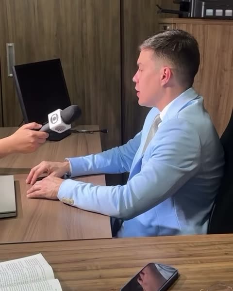 Dr. Alisson de terno azul dando entrevista no escritório